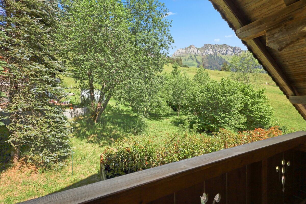 Blick vom Balkon ins Grüne mit Bergkulisse