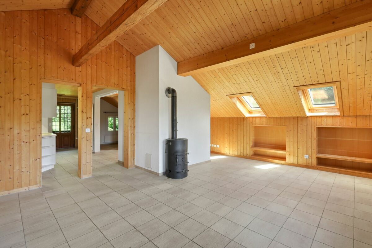 Dachgeschossraum mit Holzverkleidung und Ofen