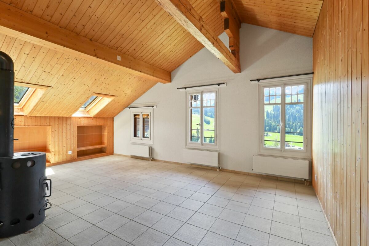 Dachgeschossraum mit Holzbalken und Alpenblick