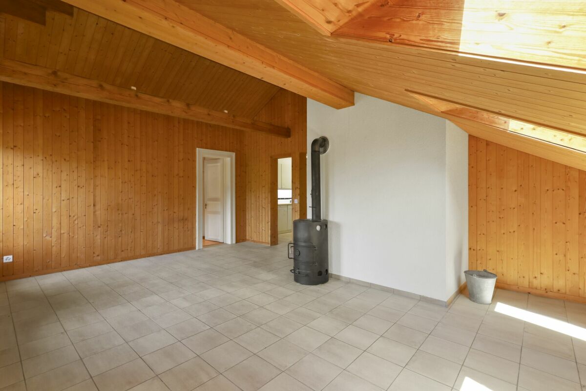 Heller Dachraum mit Holzverkleidung und Kaminofen