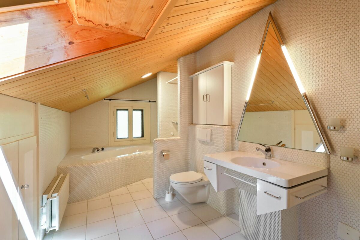 Dachgeschoss-Badezimmer mit Badewanne und Waschtisch