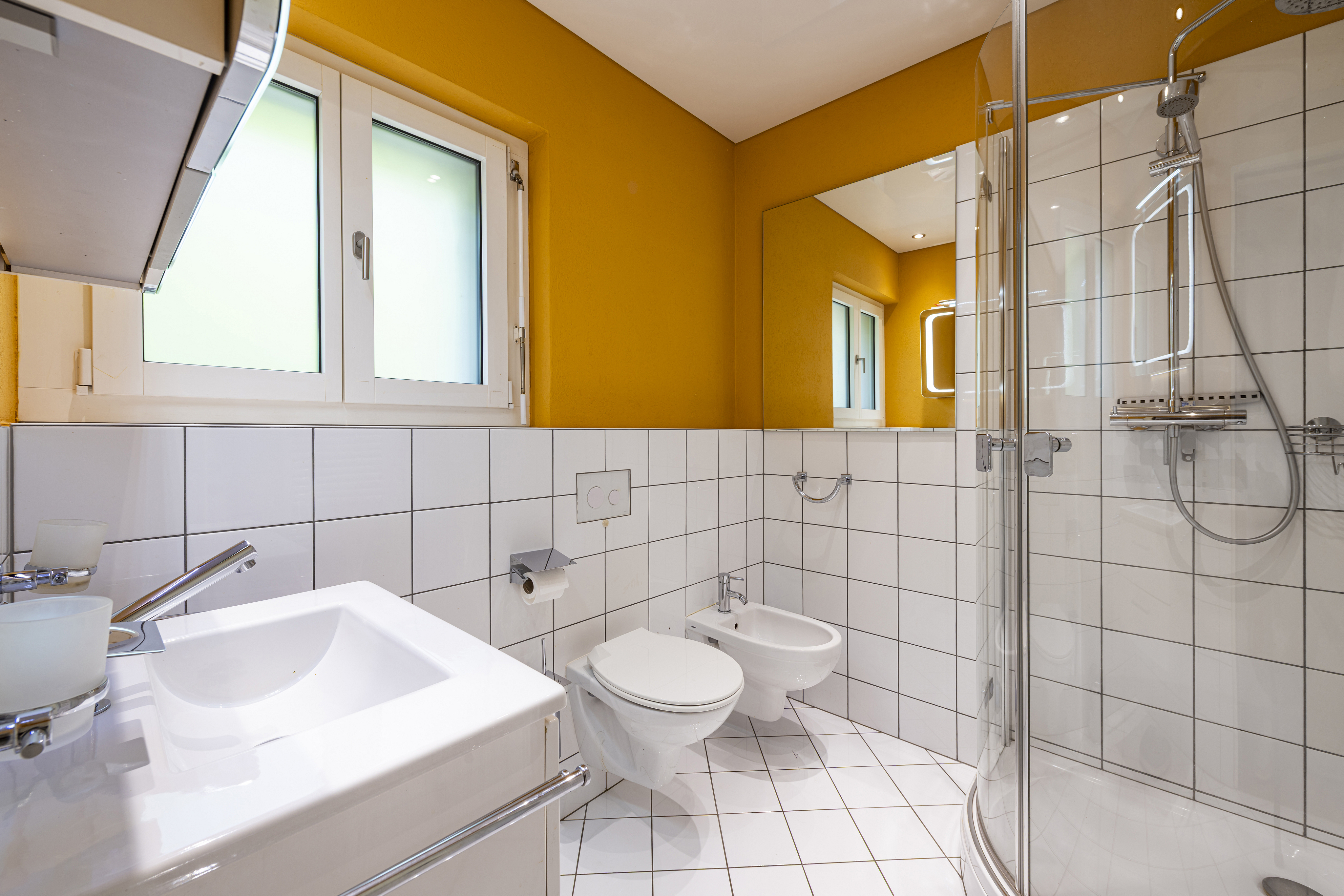 Helles, modernes Badezimmer mit Dusche, WC und Waschtisch