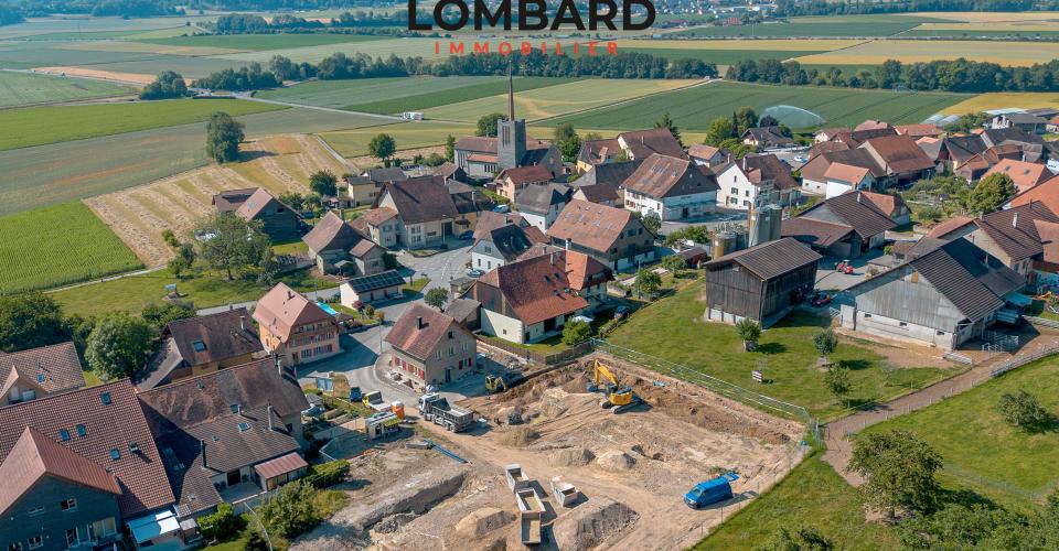 Luftaufnahme eines Dorfes mit Baustelle