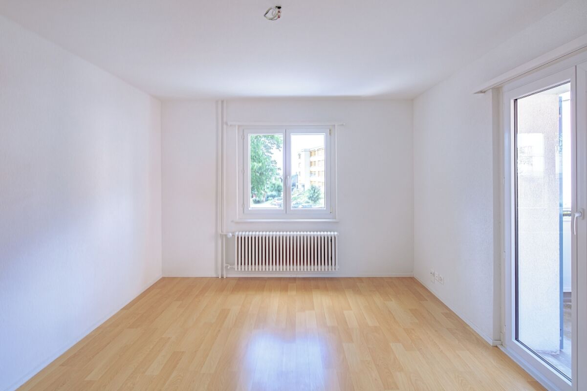 Heller leerer Wohnraum mit Fenster und Heizkörper