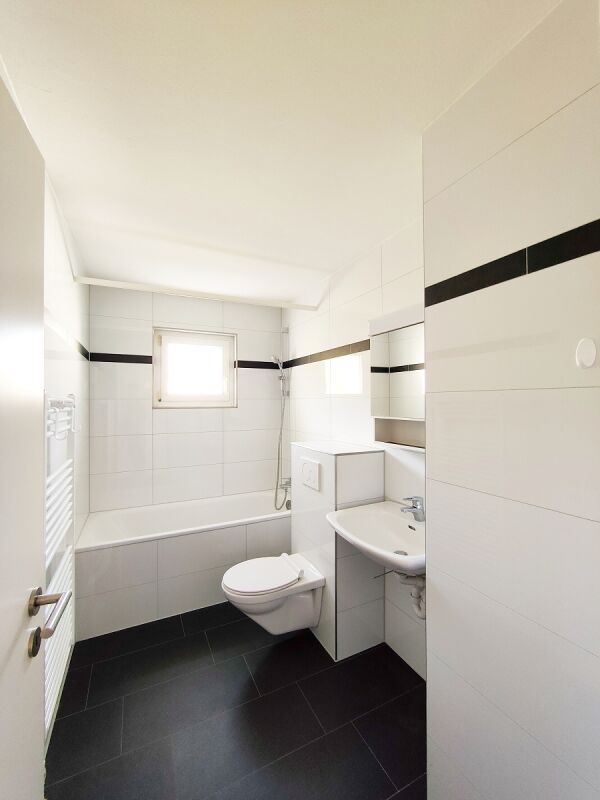 Helles Badezimmer mit Badewanne und Wand-WC