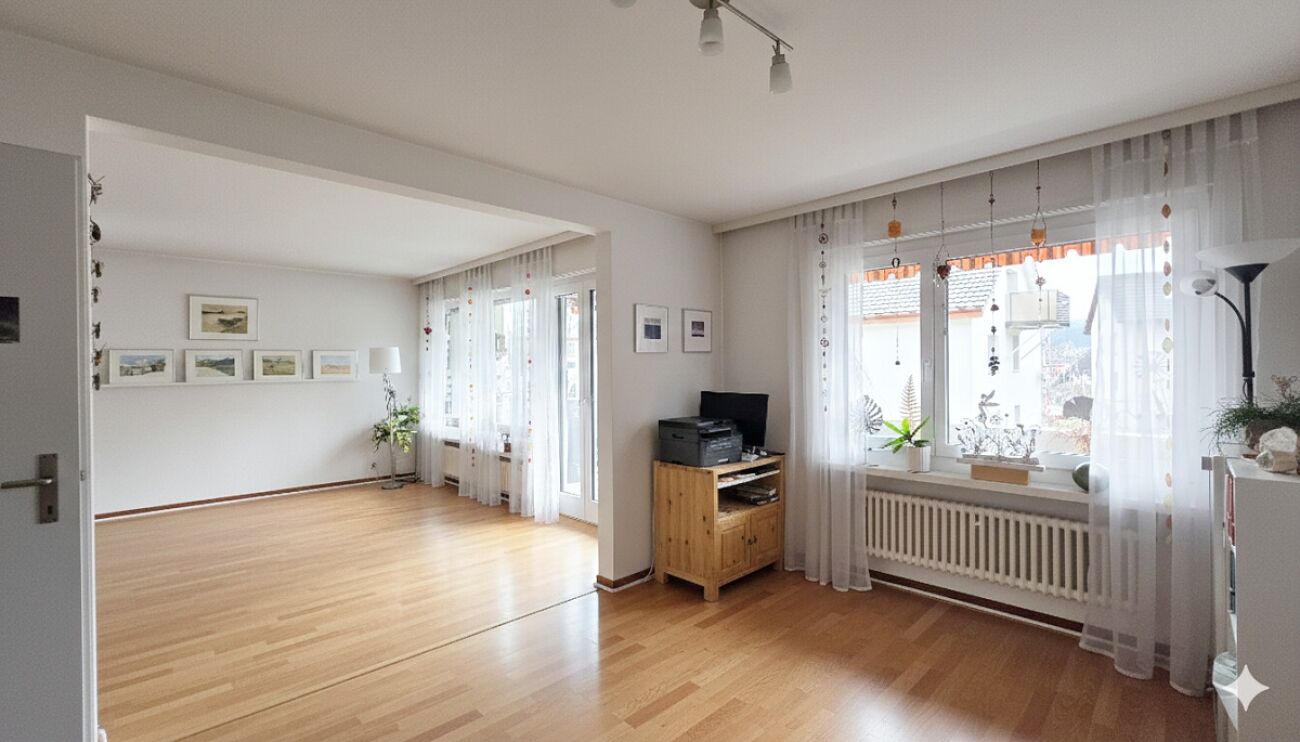 Heller Wohnraum mit Durchgang und großen Fenstern