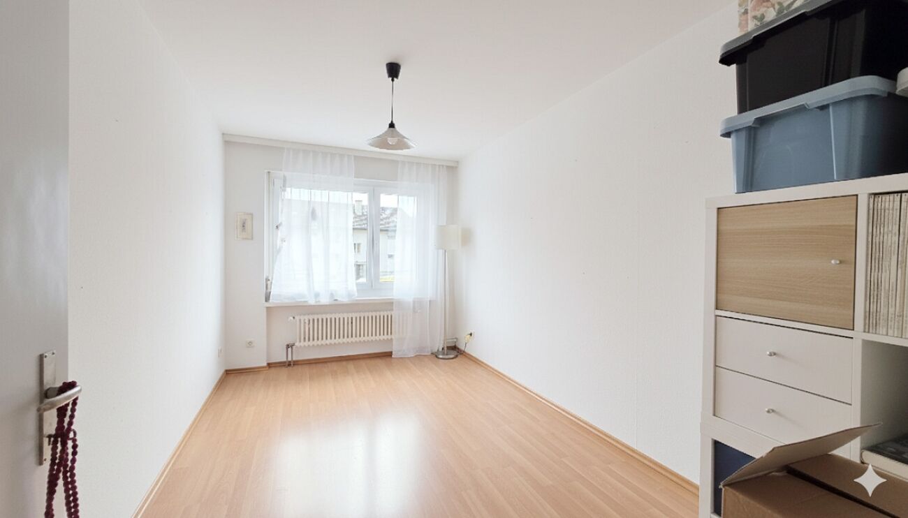 Helles, schmales Zimmer mit Fenster und Stauraumregal