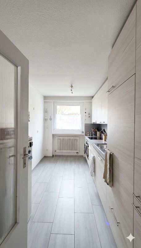 Schmale, helle Küche mit Fensterfront