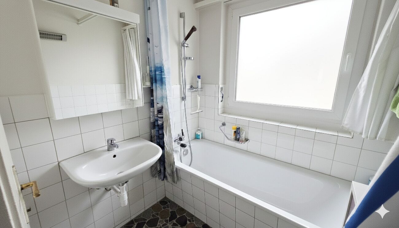 Kleines weiß gefliestes Badezimmer mit Badewanne