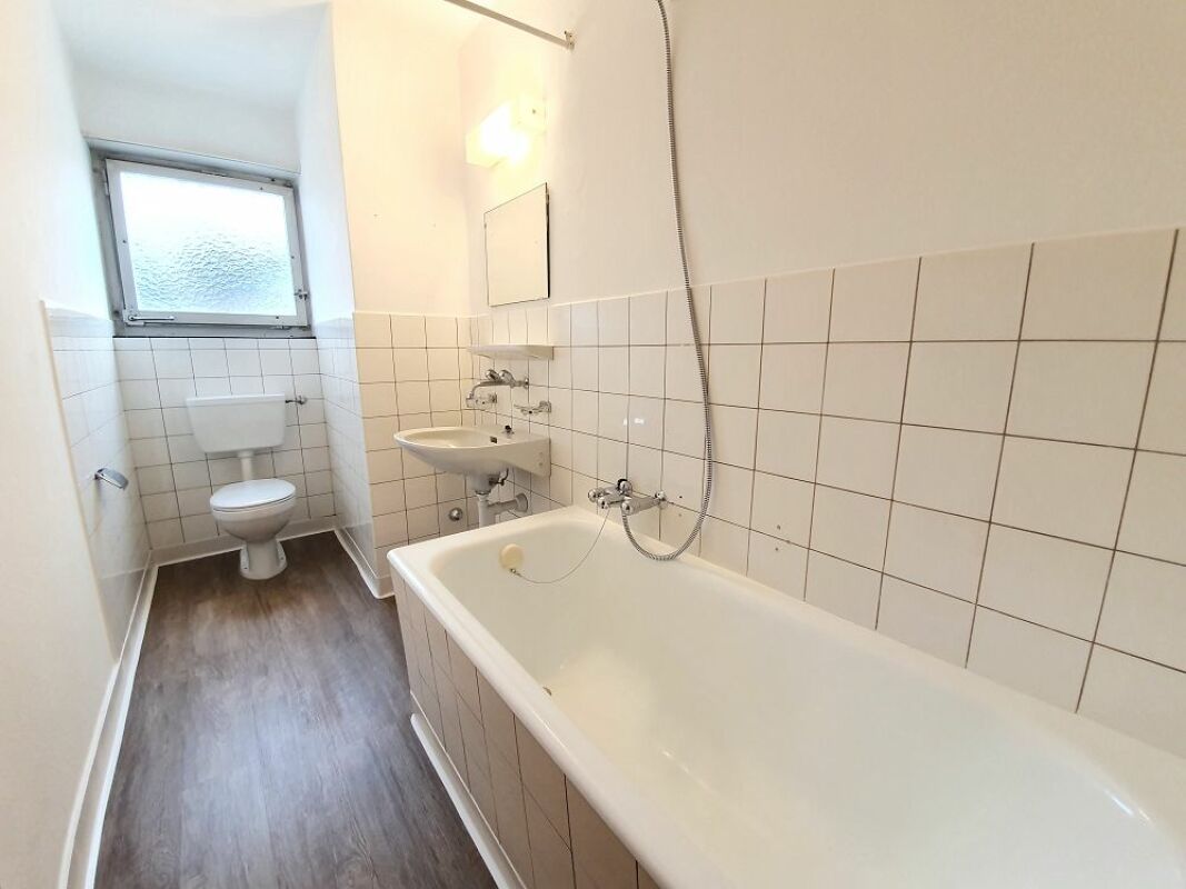 Schmales Badezimmer mit Badewanne und WC