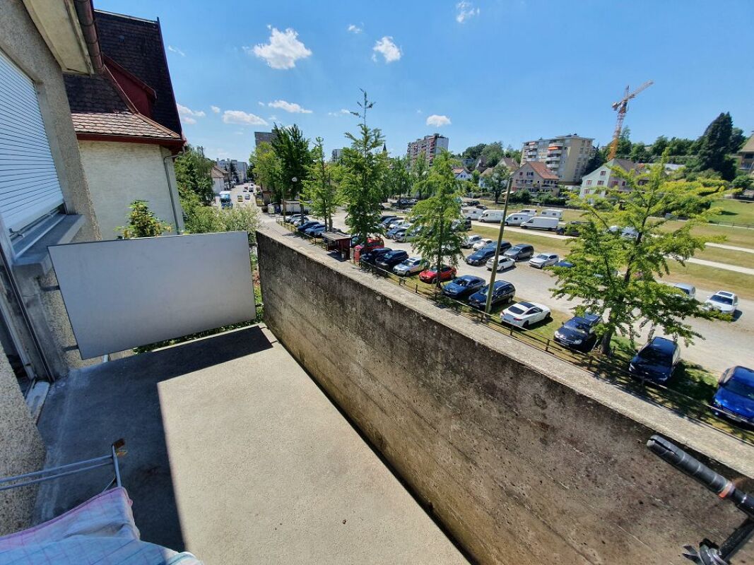 Balkon mit Ausblick auf Parkplatz und Wohnumfeld