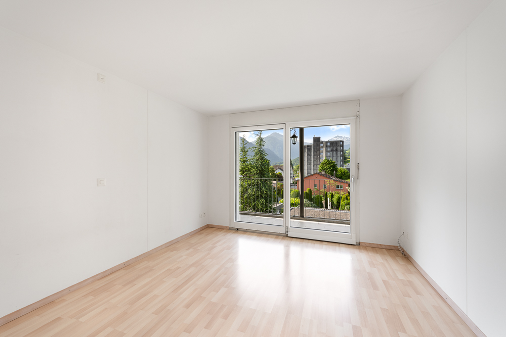Leerer heller Raum mit Balkon- oder Terrassentür und Bergblick