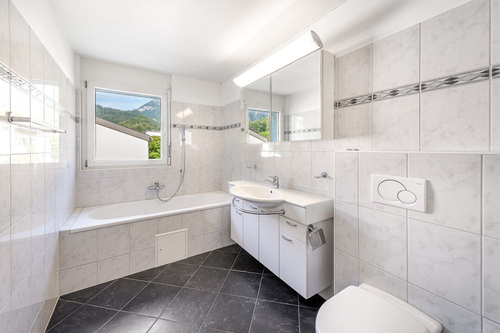 Badezimmer mit Badewanne und Fensterblick