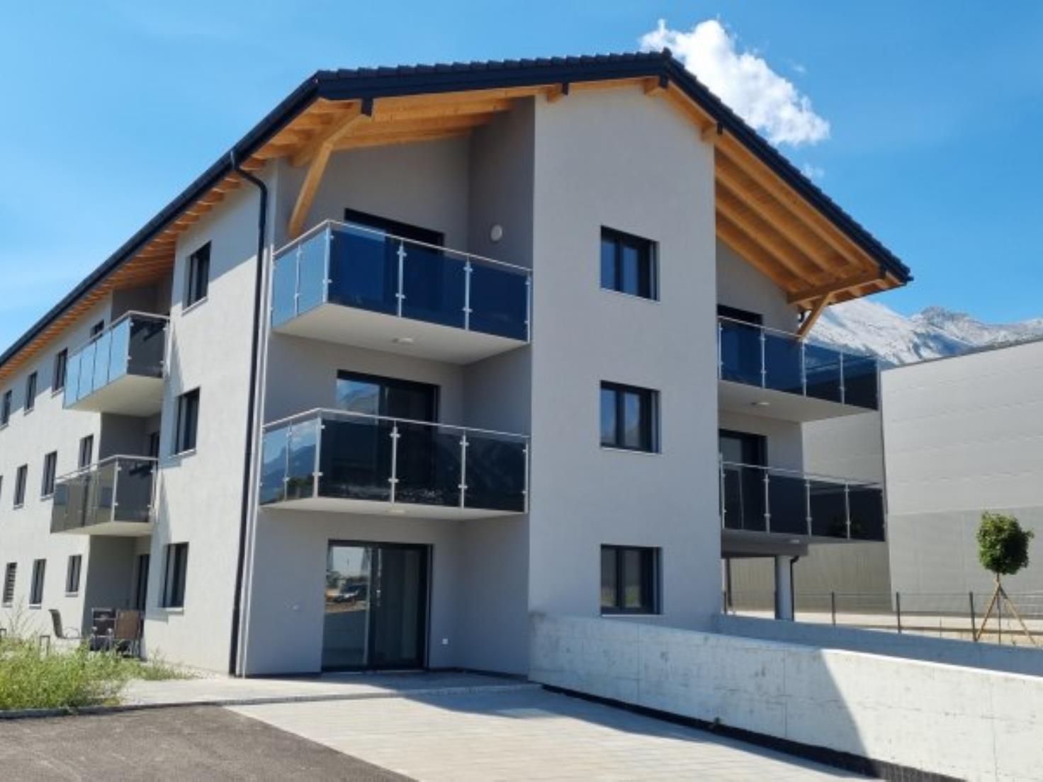 Modernes Mehrfamilienhaus mit Balkonen und Bergblick