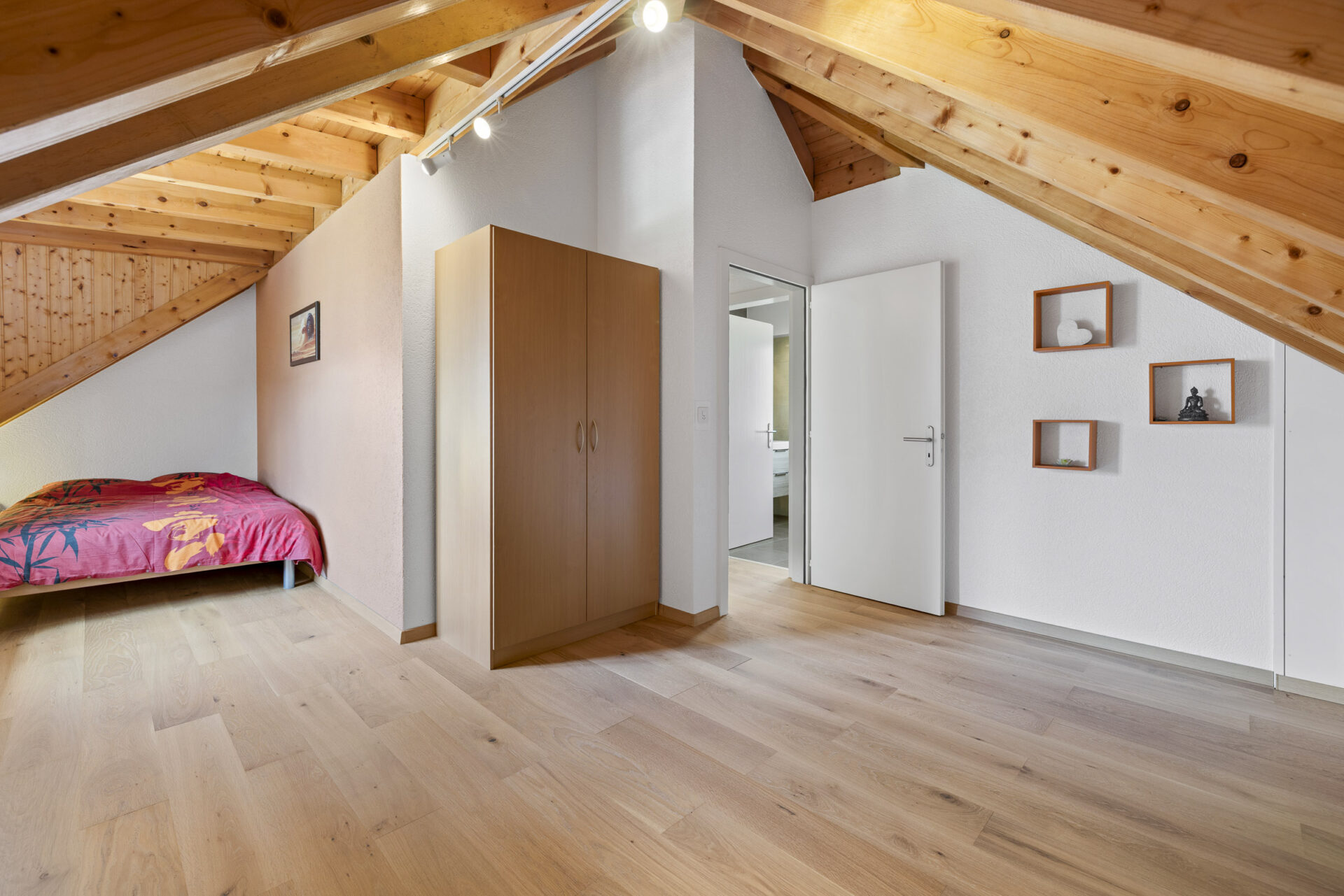 Dachgeschoss-Schlafzimmer mit sichtbaren Holzbalken