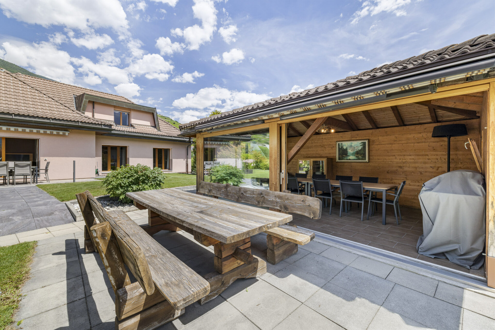 Überdachte Terrasse mit Garten und Blick auf das Wohnhaus