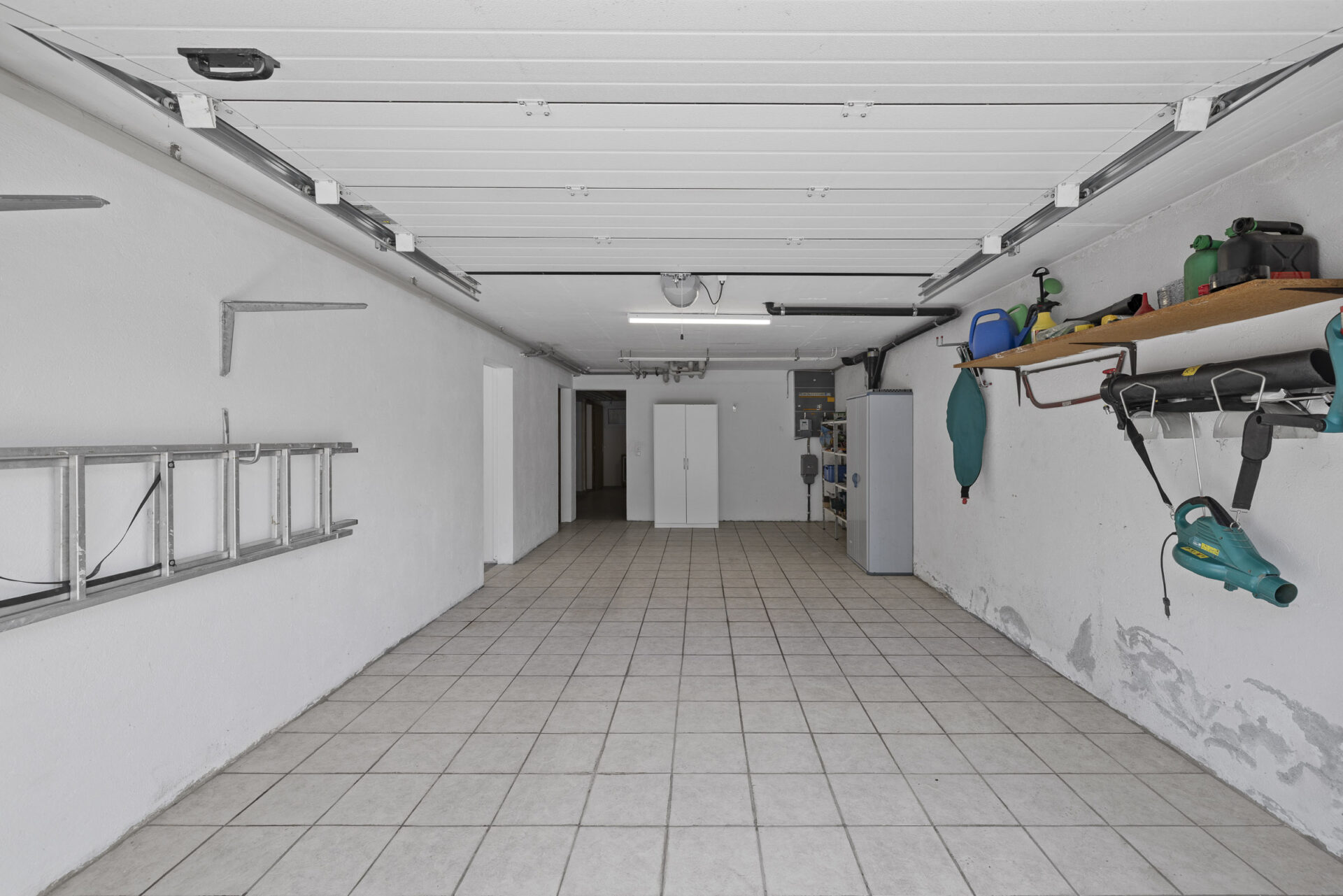 Geräumige Garage mit Fliesenboden und Werkstattlagerung