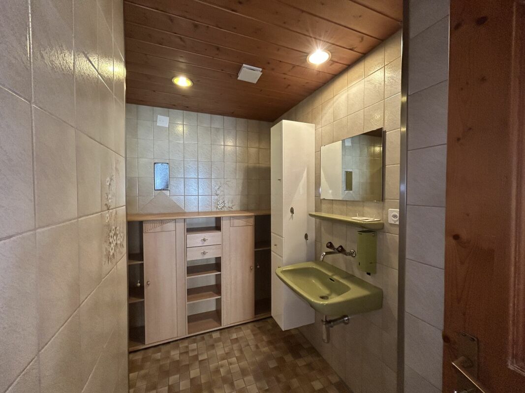 Badezimmer mit Holzdecke und Einbaumöbeln