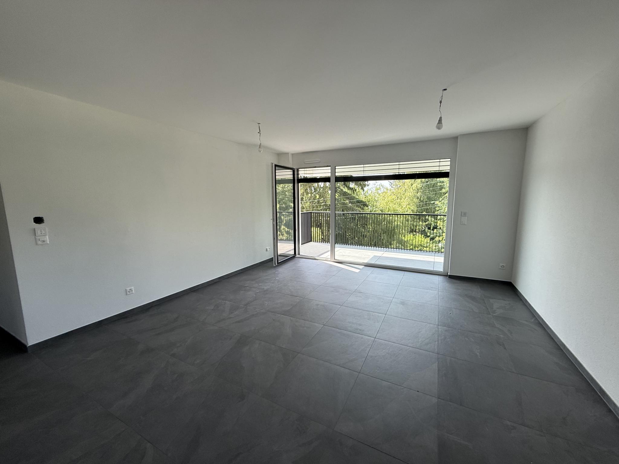 Leerer moderner Wohnraum mit Balkonzugang