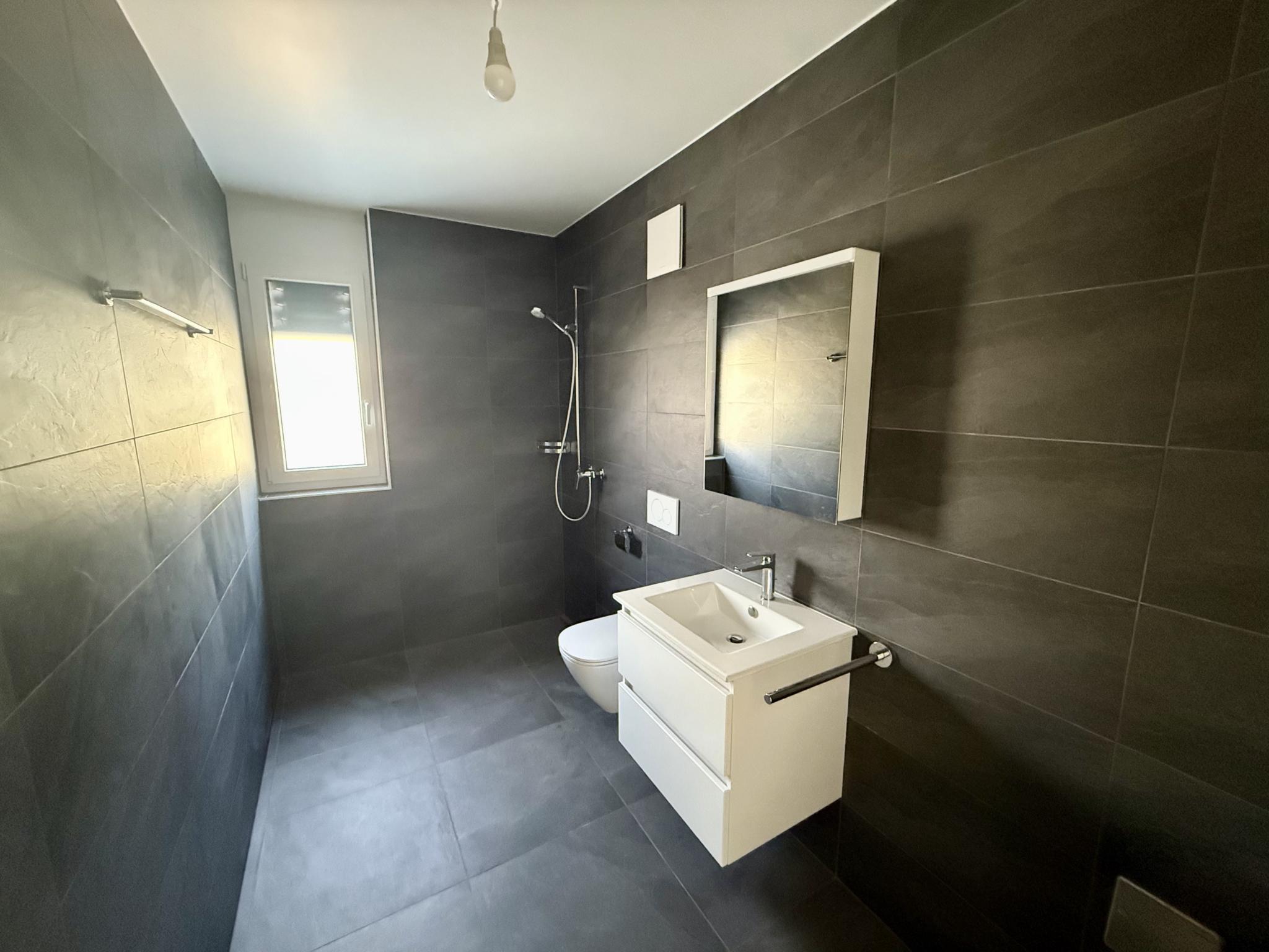 Modernes Badezimmer mit dunklen Fliesen