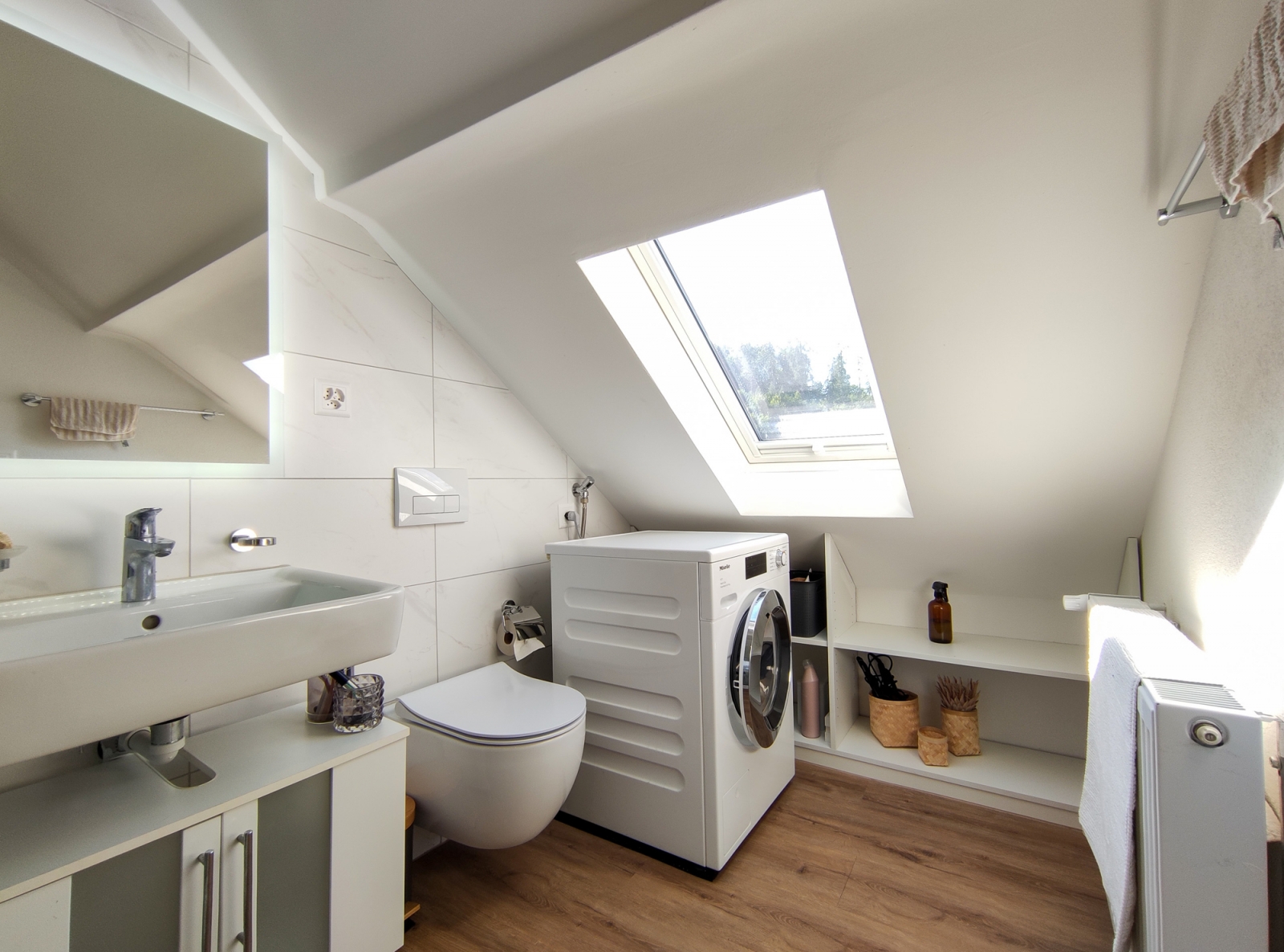 Helles Dachgeschoss-Badezimmer mit Waschmaschine und WC
