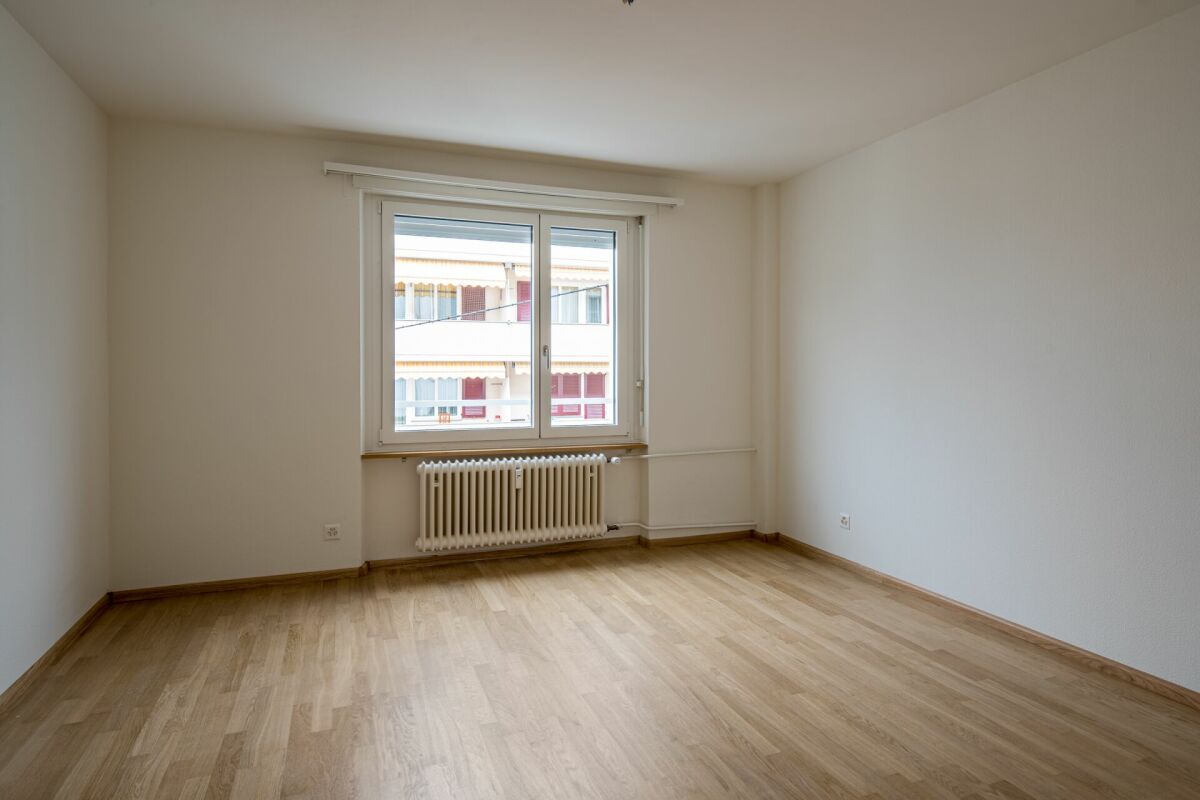 Leerer Wohnraum mit Fenster und Heizkörper