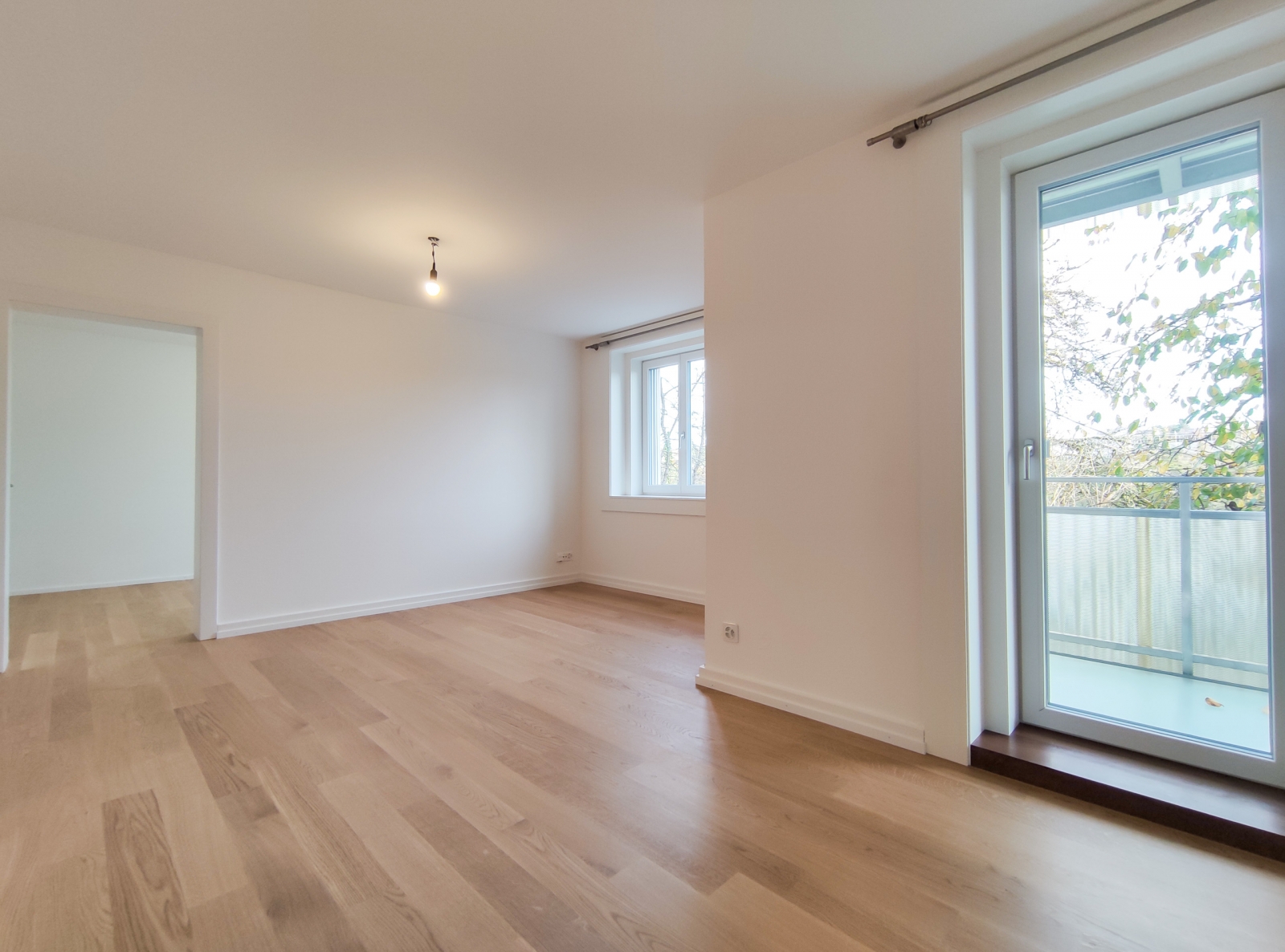 Helles, leeres Zimmer mit Balkonzugang