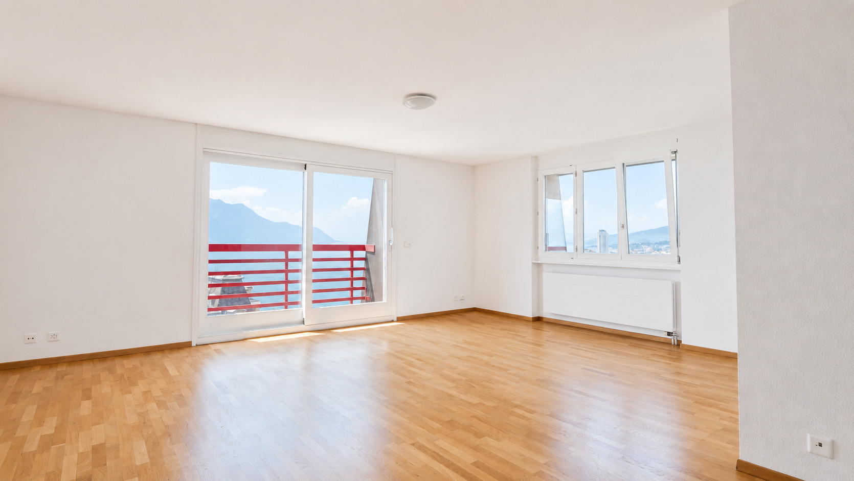 Heller leerer Wohnraum mit Balkon und Bergblick