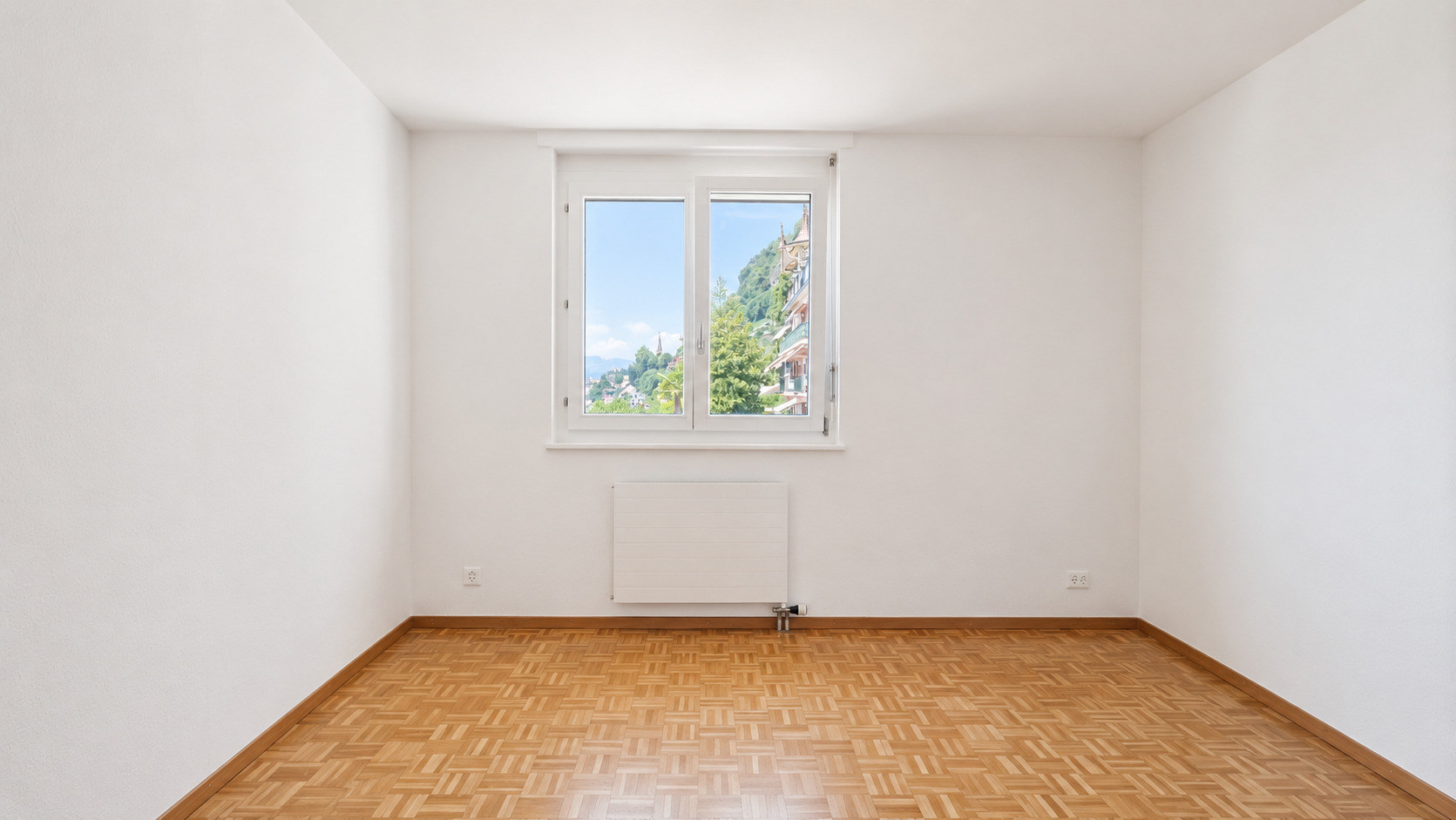 Leerer heller Raum mit Parkett und Fensterblick