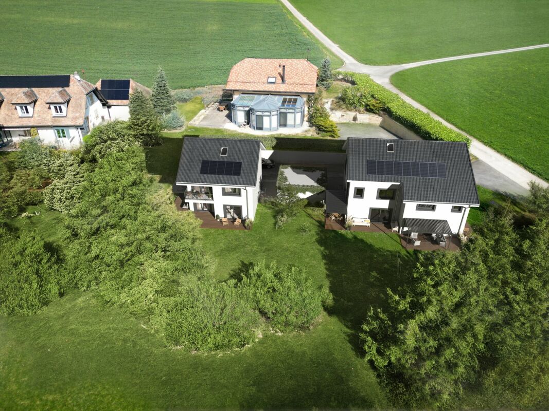 Luftaufnahme eines ländlichen Grundstücks mit zwei modernen Wohnhäusern