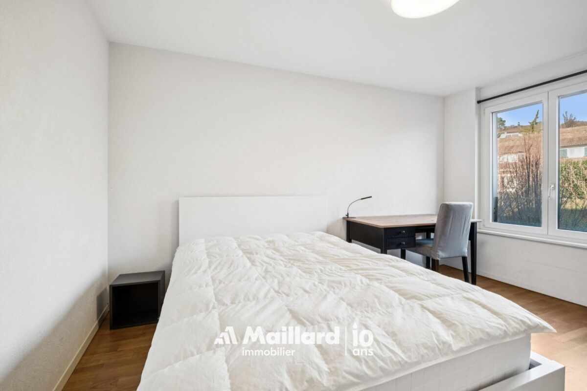 Helles Schlafzimmer mit Schreibtisch am Fenster