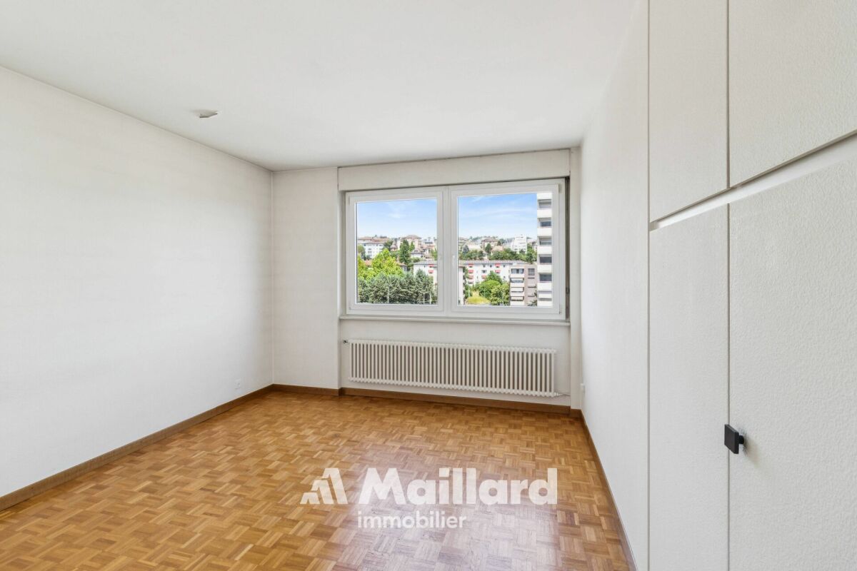 Leeres Schlafzimmer mit Parkettboden und Fensterblick