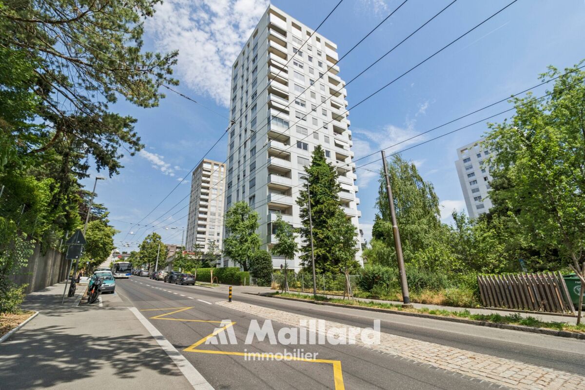 Städtische Hochhausansicht an einer Baum gesäumten Straße