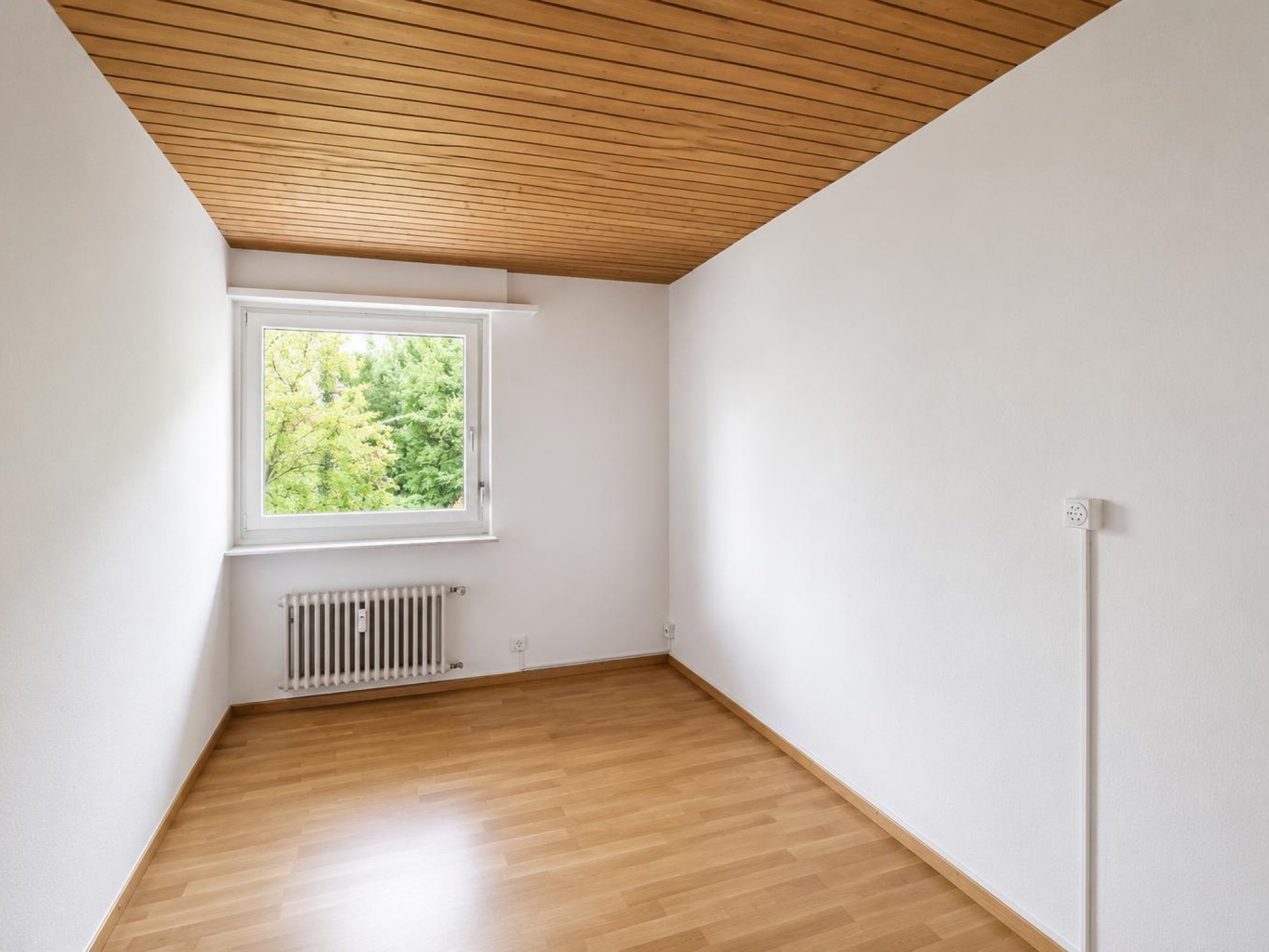 Leerer Raum mit Holzdecke und Fenster