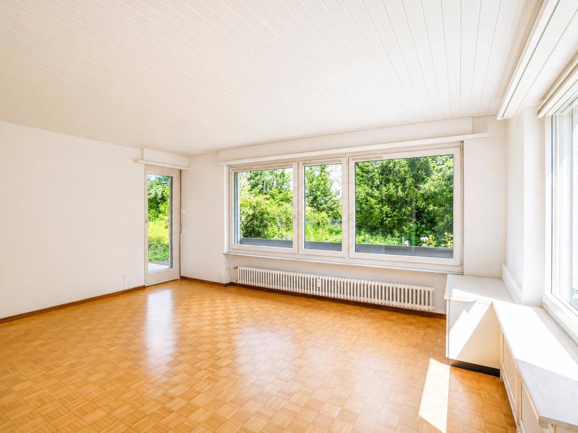 Leerer, heller Wohnraum mit großen Fenstern