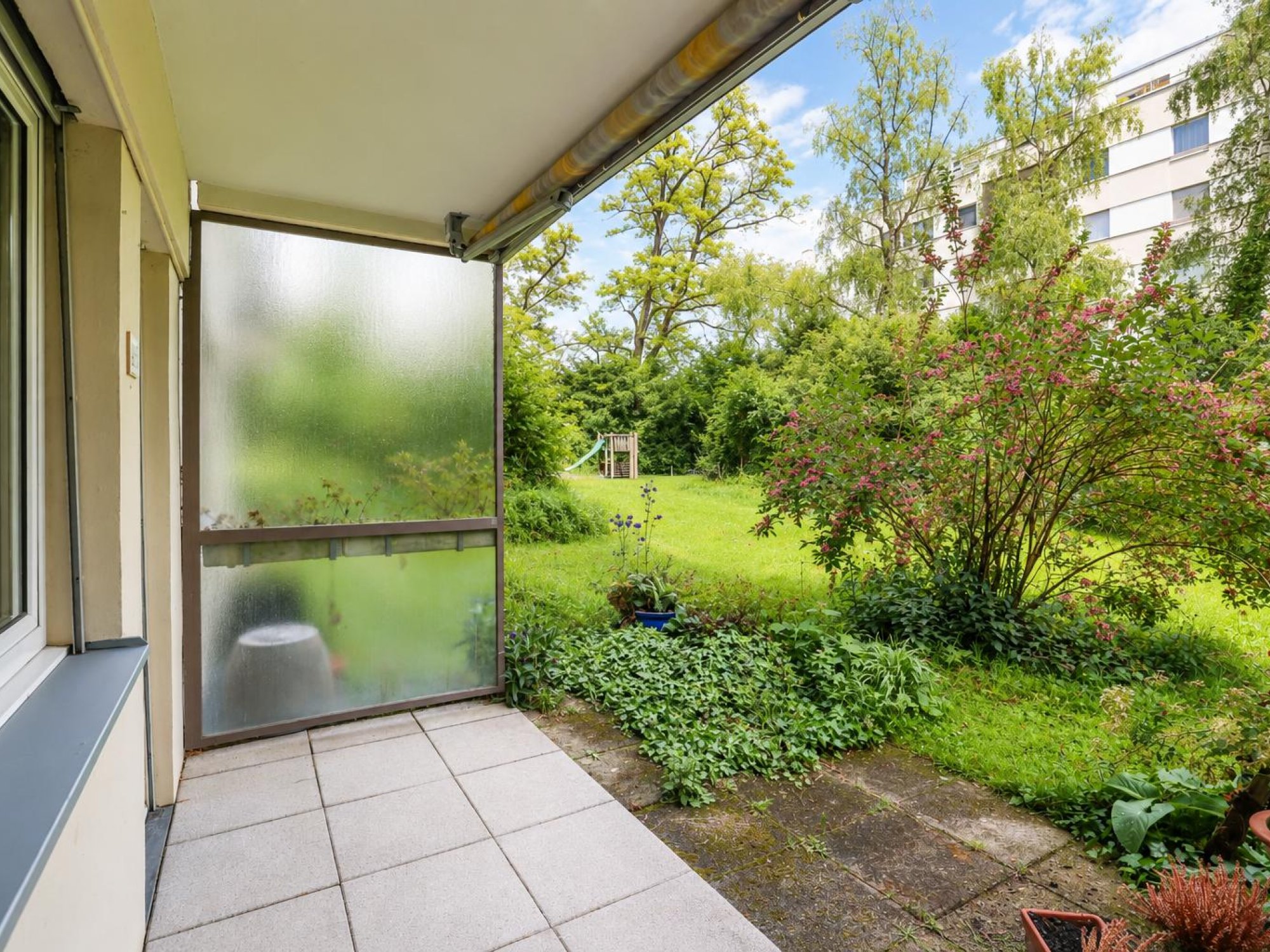 Überdachter Balkon mit Gartenblick