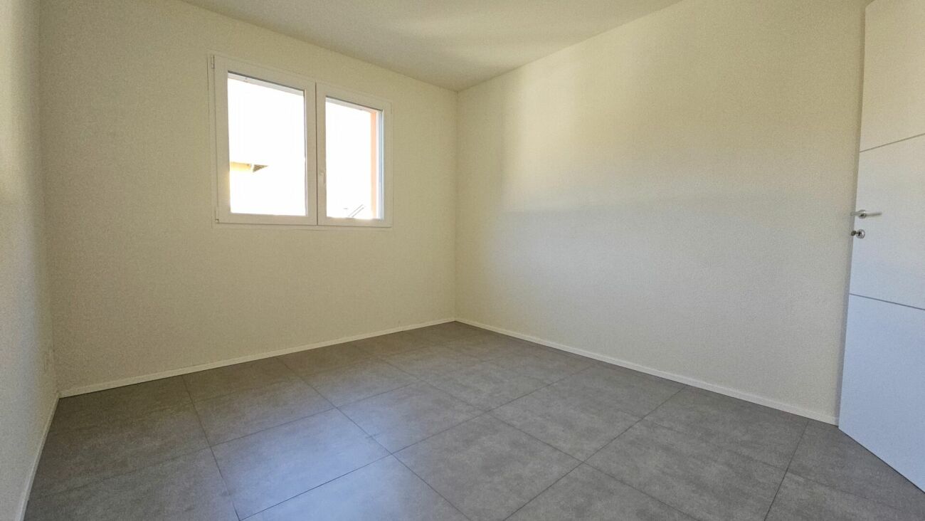 Leerer, heller Raum mit Fliesenboden und Fenster