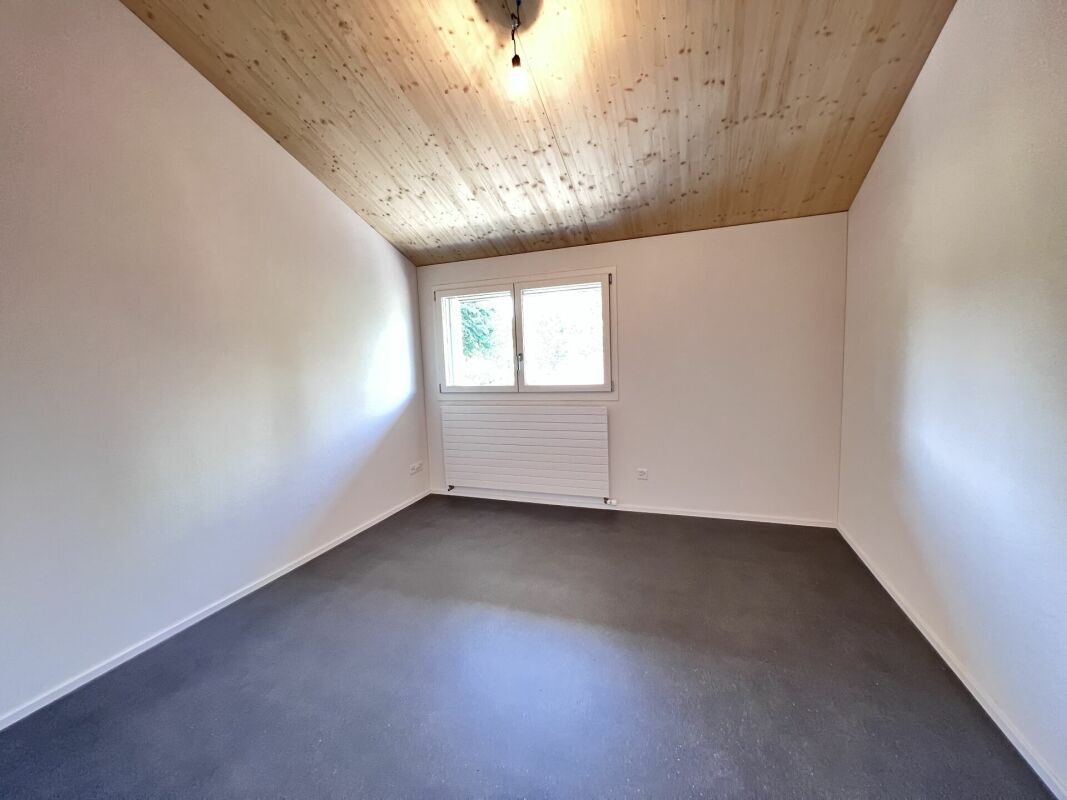 Leerer Raum mit Holzdecke und kleinem Fenster