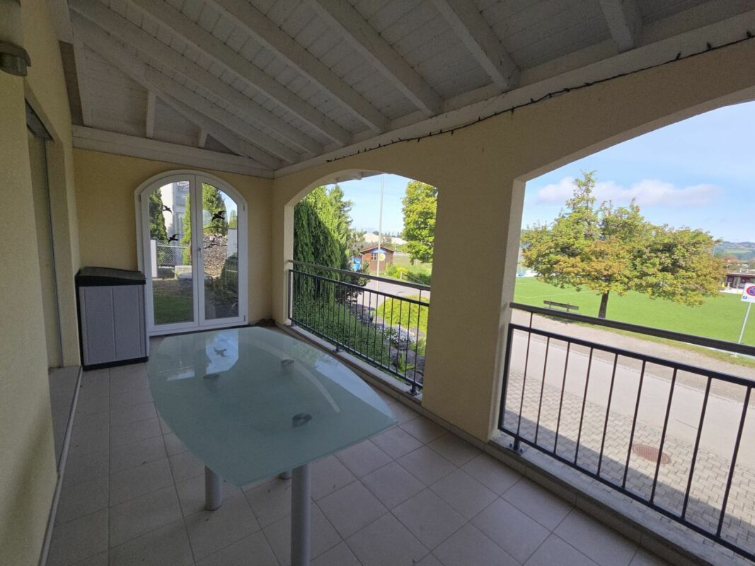 Überdachte Terrasse mit Glas-Esstisch