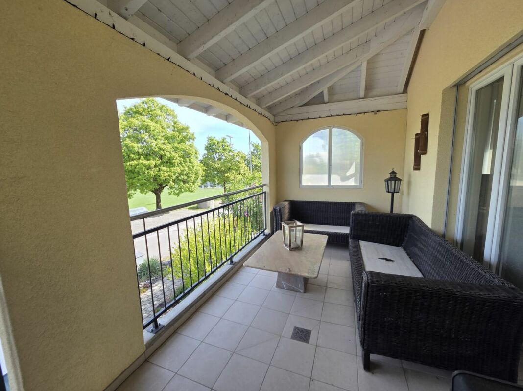 Überdachter Balkon mit Sitzgruppe