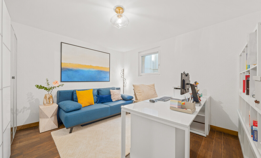 Helles Arbeitszimmer mit Sofa und Schreibtisch