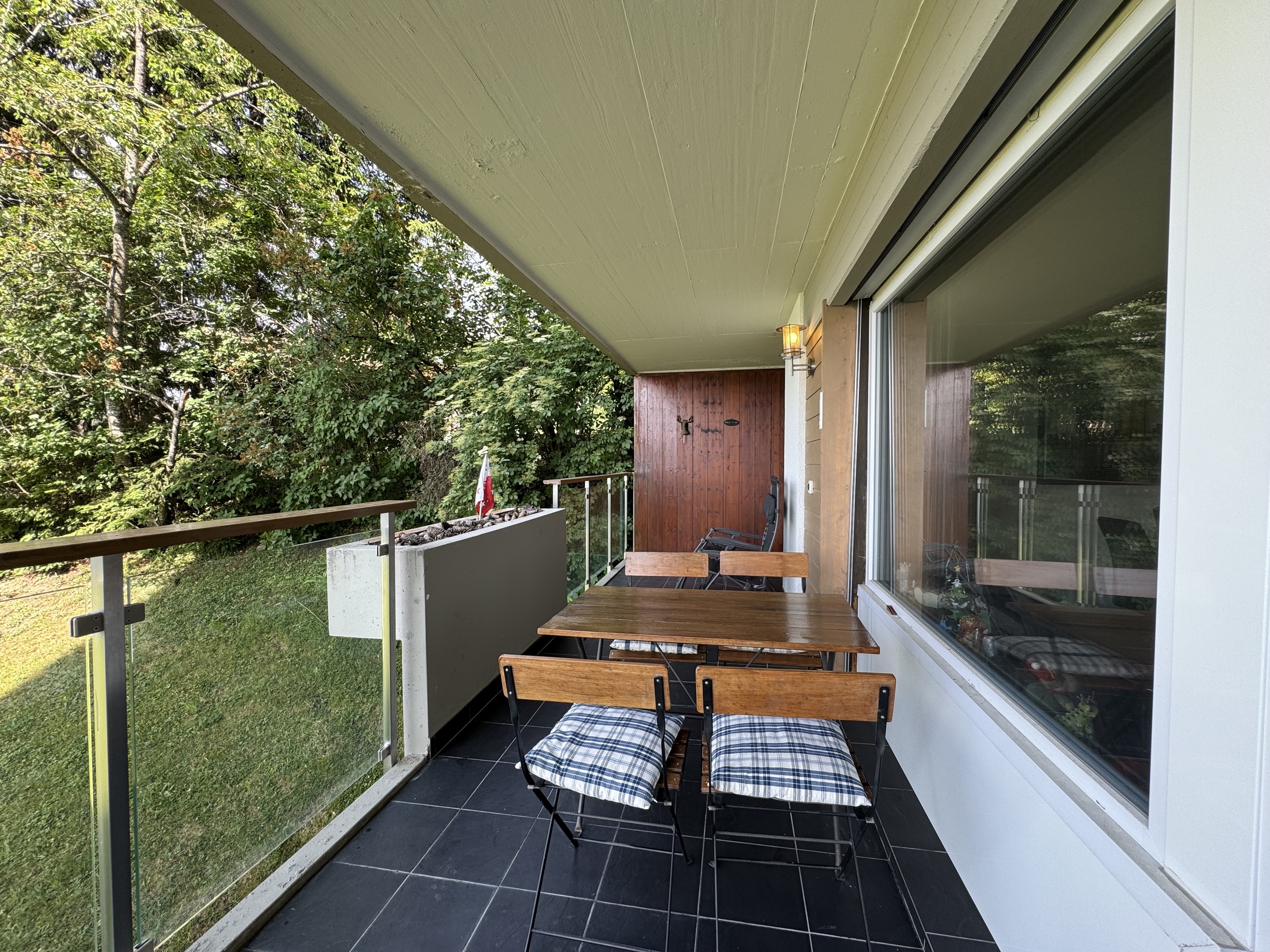 Überdachter Balkon mit Sitzgruppe