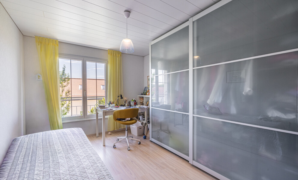Helles Schlafzimmer mit Arbeitsplatz und großem Kleiderschrank