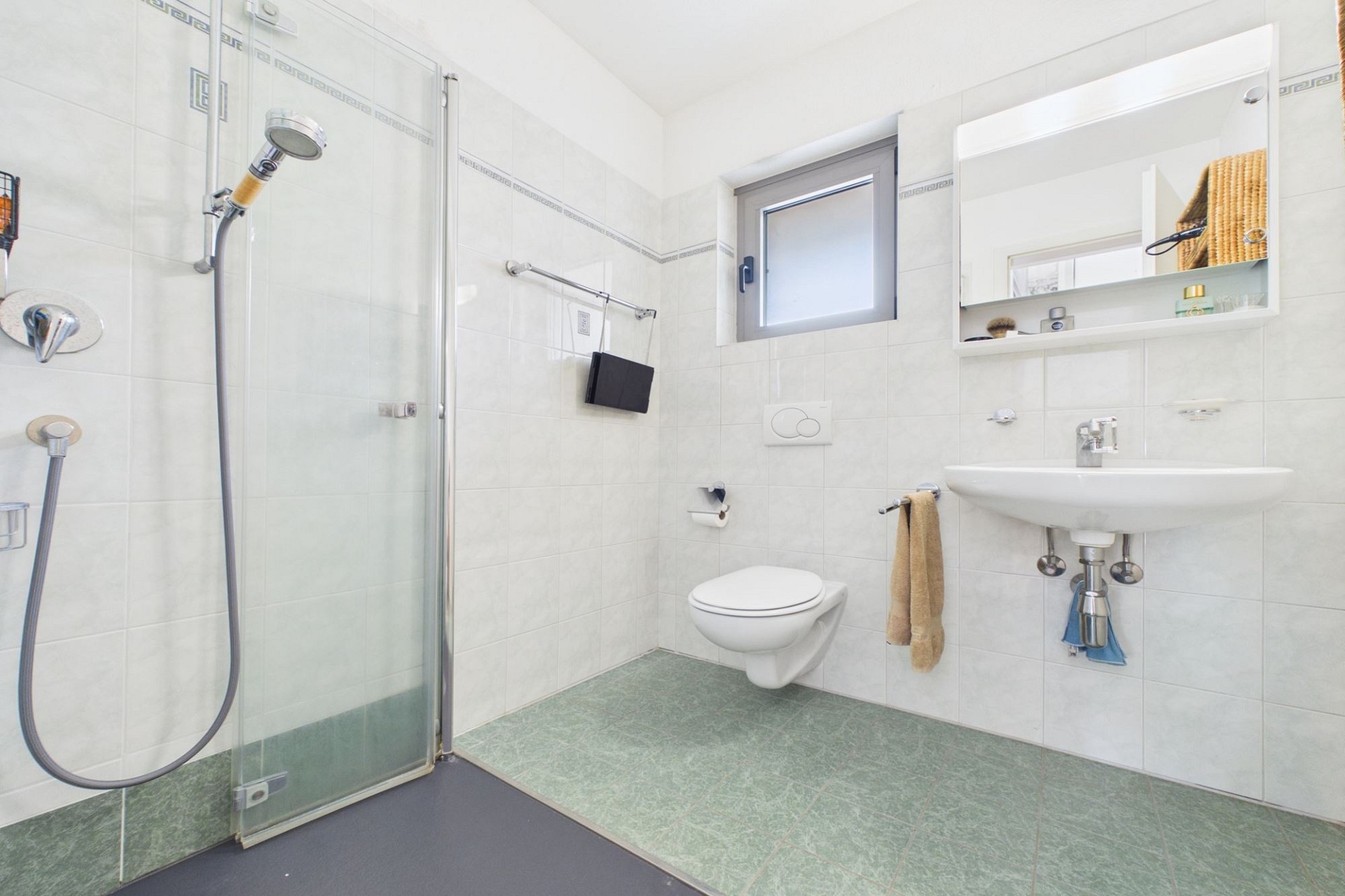 Helles Badezimmer mit Dusche, WC und Waschbecken