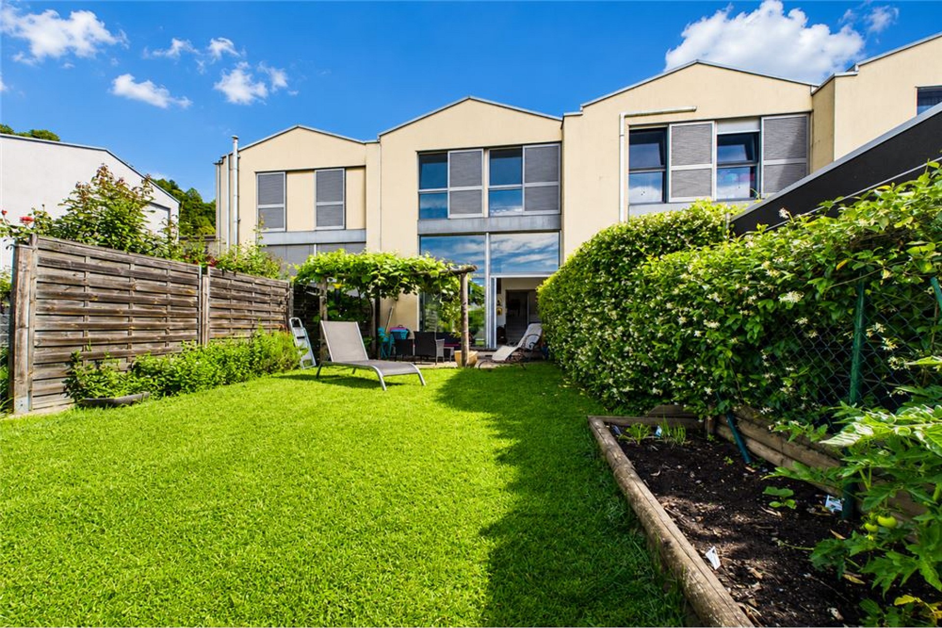 Heller Garten mit moderner Wohnanlage