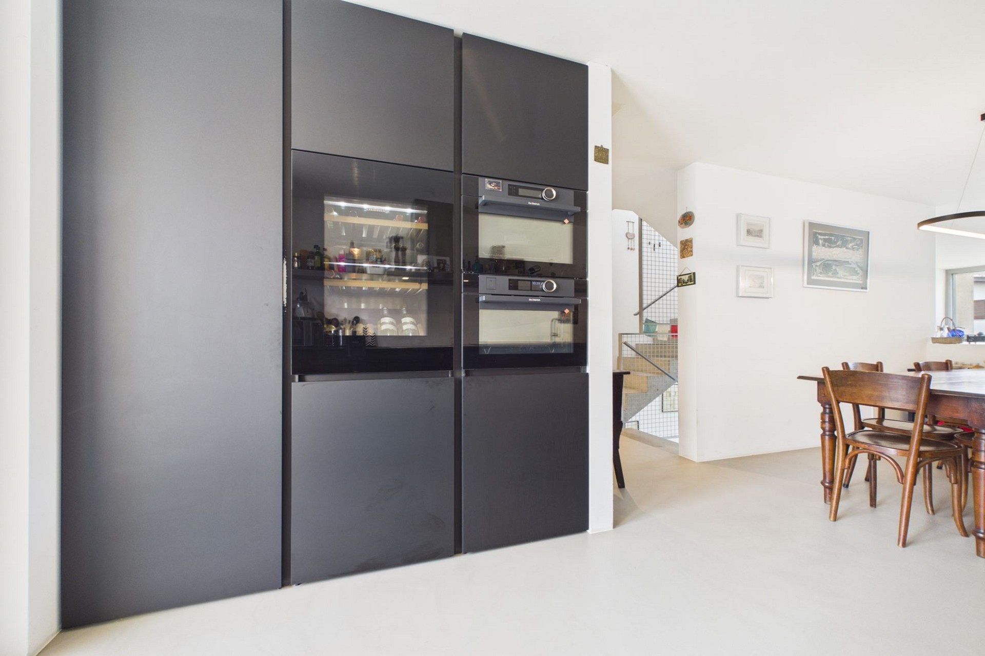 Moderner Essbereich mit schwarzer Einbauwand und Holztisch