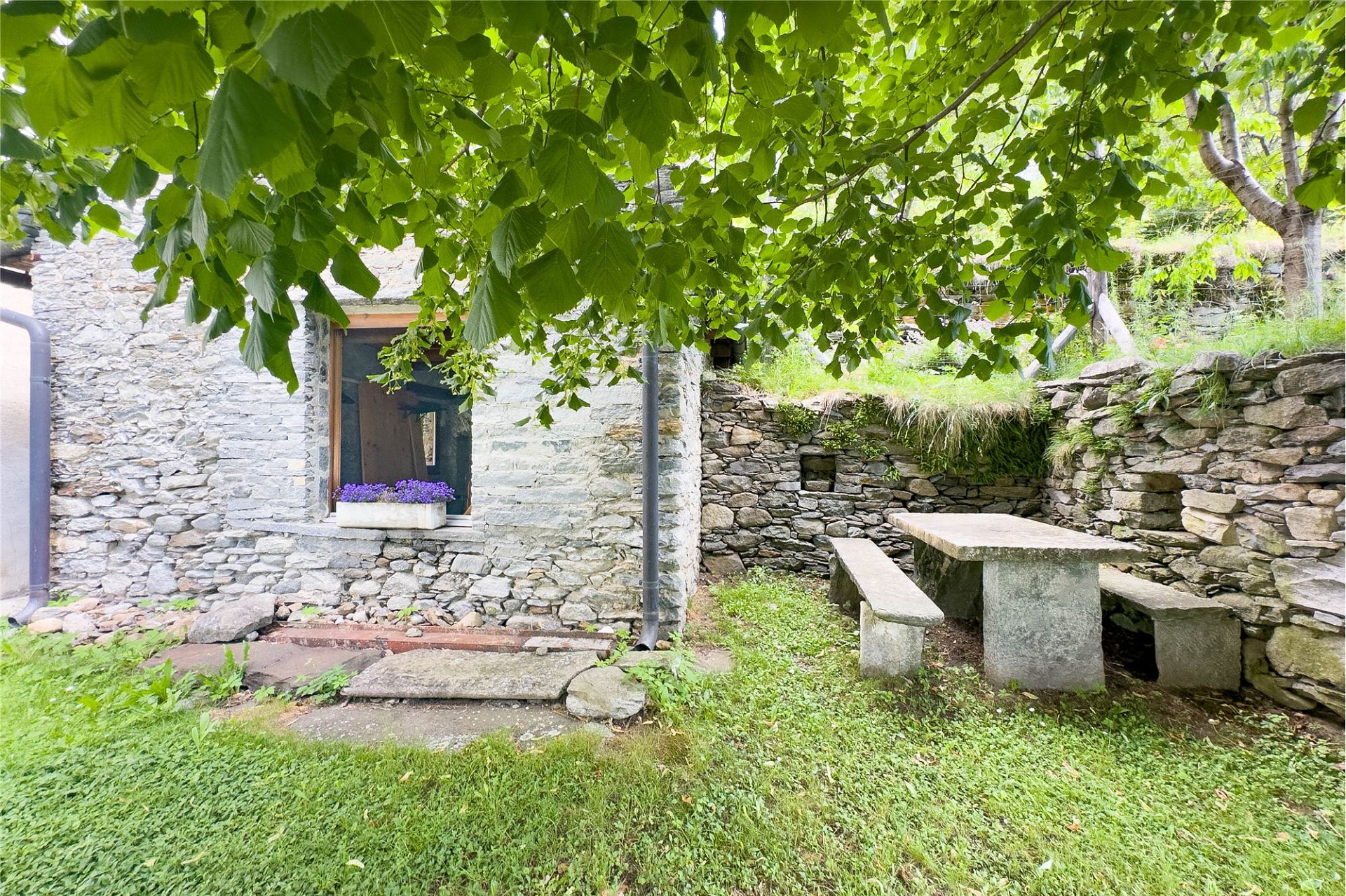 Steinerner Gartenbereich mit Sitzplatz