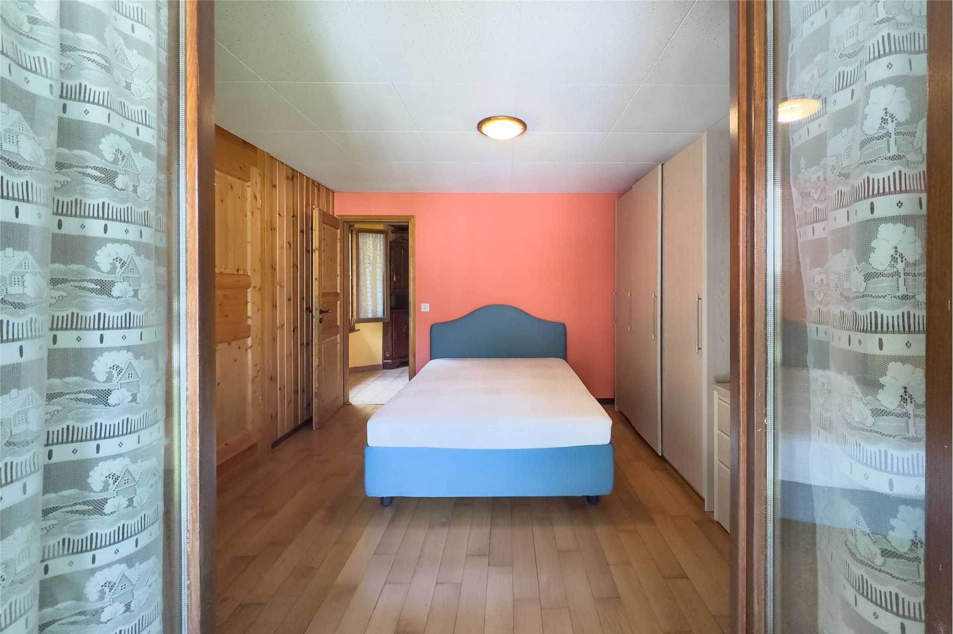 Schlafzimmer mit Holzschrank und Bett