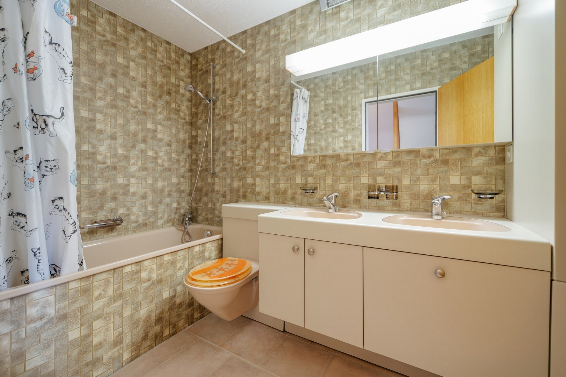 Badezimmer mit Badewanne, Doppelwaschtisch und Katzenvorhang
