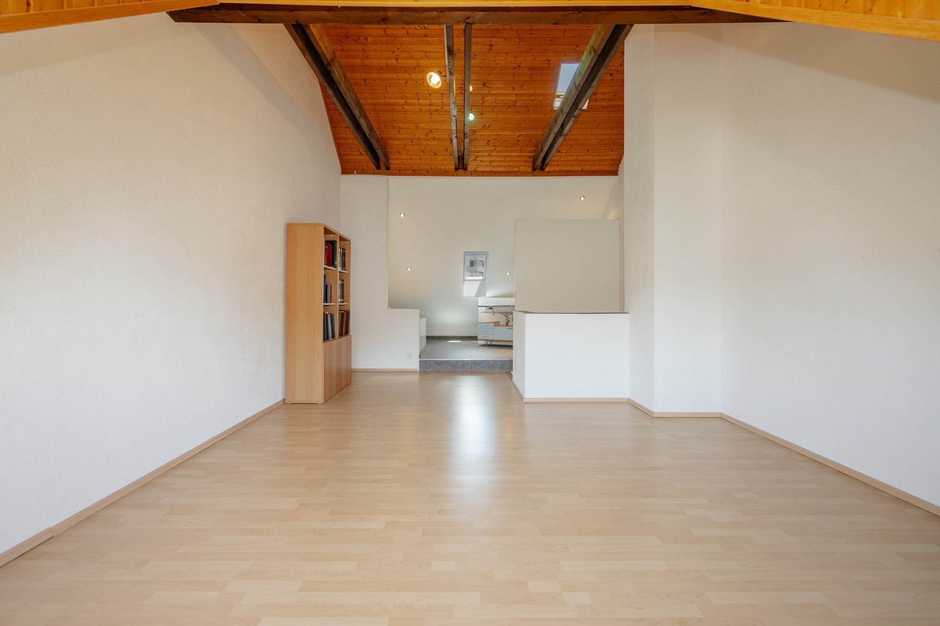 Heller, leerer Dachgeschossraum mit Holzdecke
